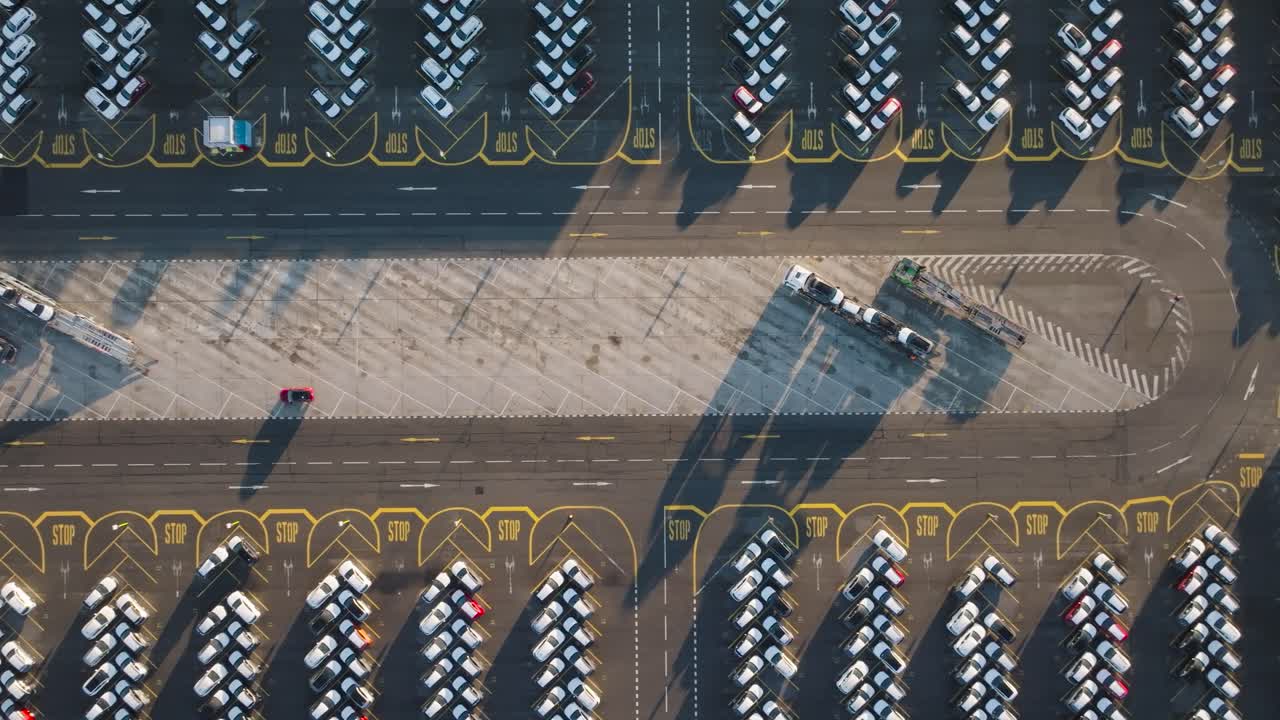Aerial top down view of company parking lot and car carrier trailer