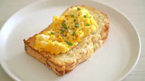 bread-toast-with-scramble-egg-on-white-plate