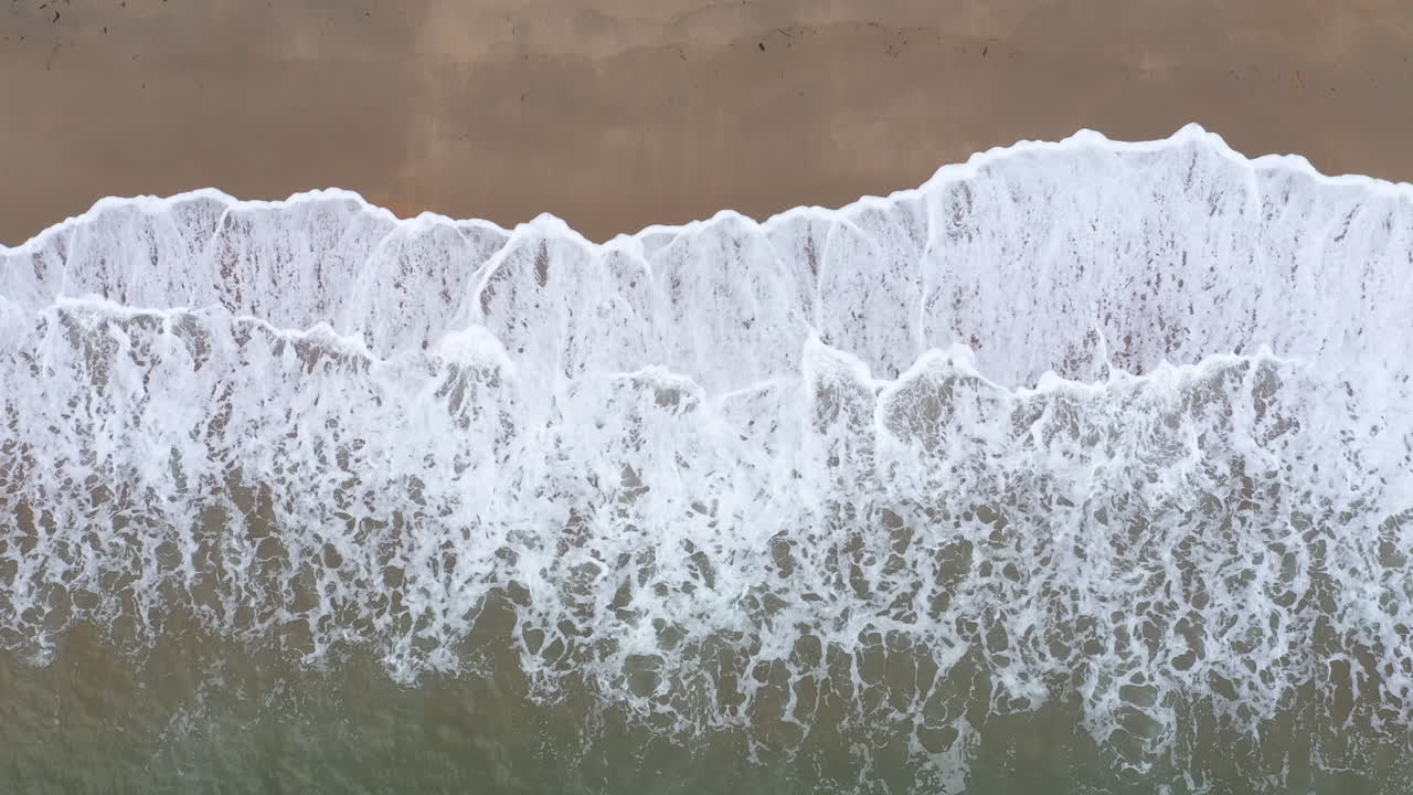 Waves crashing on a sandy beach Biarritz Anglet aerial top shot
