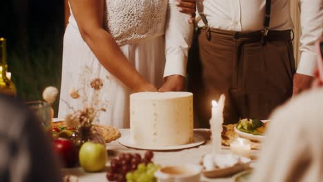 couple cutting wedding cake at outdoor reception