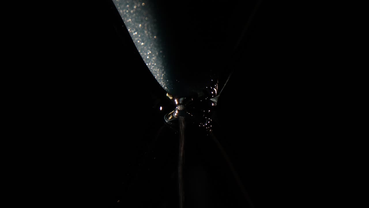 Hourglass with Sand Flowing in the Dark