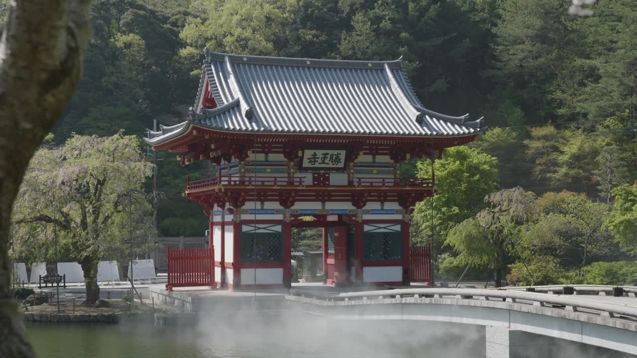 Entry gate, bridge and pond at Katsuoji Temple on a sunny day in Osaka, Japan