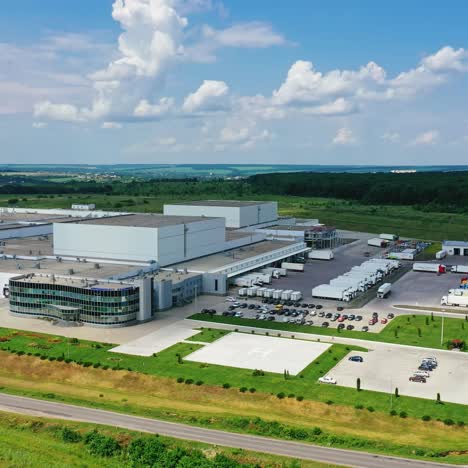 exterior of modern factory in rural place. innovative complex with car parking on green nature background. industrial zone on fields. aerial view.