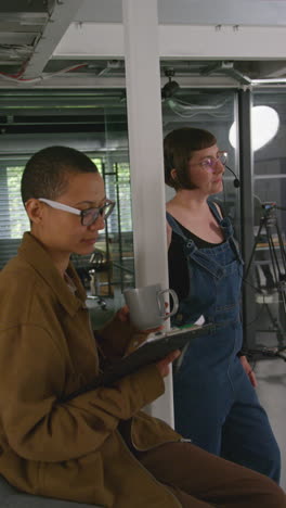 Vertical-Video-Of-Frustrated-Female-Film-Director-Watching-Performance-Of-Actors-On-Monitor-Shooting-Movie-In-Studio-Shot-In-Real-Time