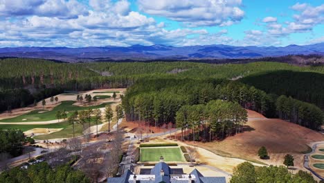 drone shows stunning view of the jack nicklaus signature golf course and club house at the reserve at lake kiwi. blue ridge mountains in background.