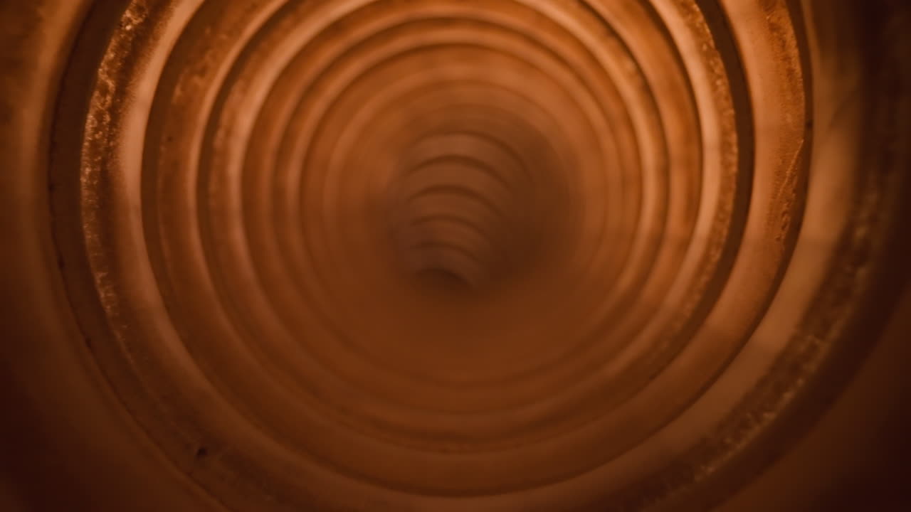 Fuoriuscita di polvere dal tubo impolverato di un aspirapolvere in una stanza luminosa.