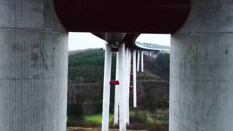 Vuelo-Entre-2-Pilares-De-Hormigón-Del-Puente-De-Autopista-Más-Alto-Del-Norte-De-Rhine-westphalia-El-Puente-De-Autopista-Talbrücke-Nuttlar-Conecta-La-Región-De-Sauerland