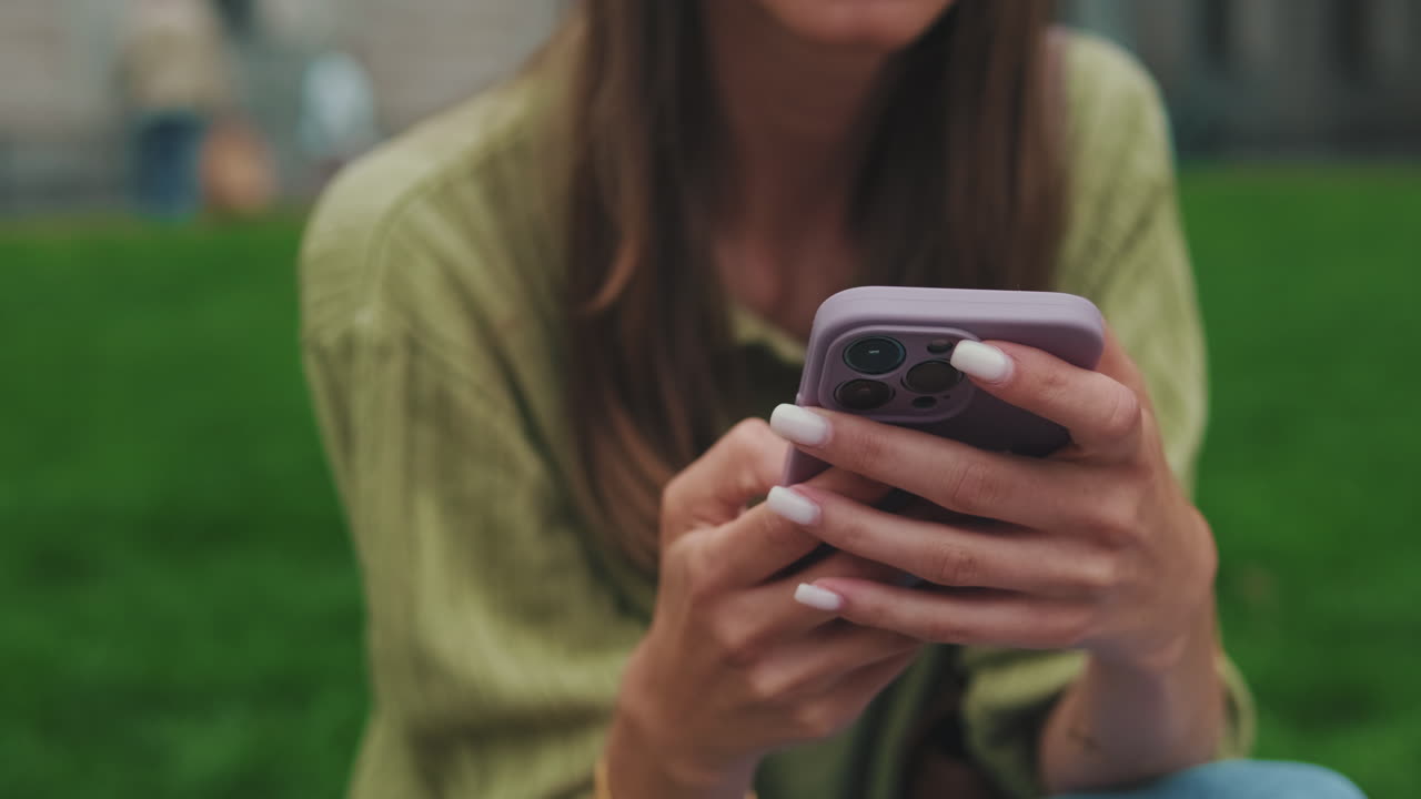 Close-up of Woman's Hands Using Smartphone Outdoors