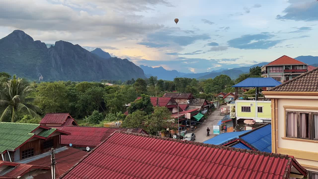 Timelapse della piccola città di Vang Vieng in Laos, con mongolfiere che passano velocemente e un paesaggio mozzafiato sullo sfondo