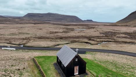 Flying-Over-Black-Church-In-Krysuvik,-Iceland---drone-shot