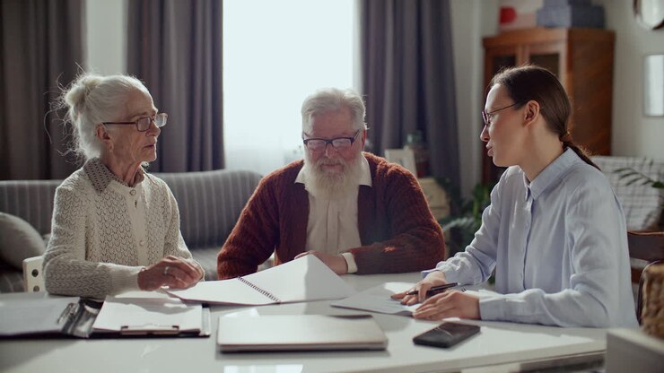 Financial Consultant Discussing Documents with Elderly Couple at Home