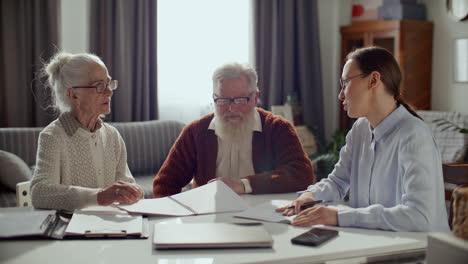 financial consultant discussing documents with elderly couple at home