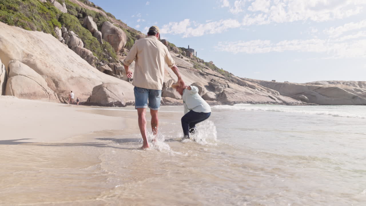pareja de alto nivel, playa y tomados de la mano