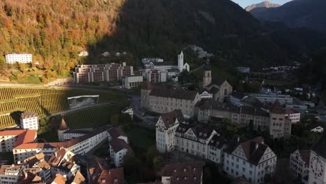 aerial view of the historic city of chur, switzerland, bathed in the warm light of the setting sun. the iconic cathedral of st. lucius dominates the skyline, adding to the city's charm and history.
