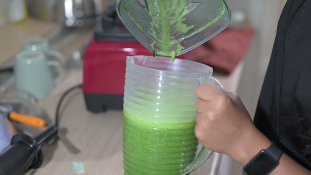 Freshly prepared green smoothie poured to container horizontal shot