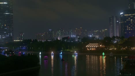 beautiful romantic night park view with river in the city town lights and boats high angle panorama cityscape view