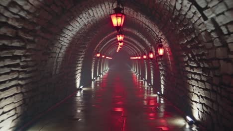red lanterns hanging from the ceiling cast a warm glow over a mysterious, misty stone tunnel at night, enhancing the dramatic atmosphere and evoking a sense of adventure