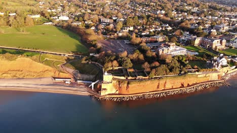 aerial view of the clock tower and connaught gardens with sidmouth town in background in morning light. dolly back tilt up