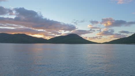 seascape with mountains in background at sunrise - whitsunday islands in qld, australia