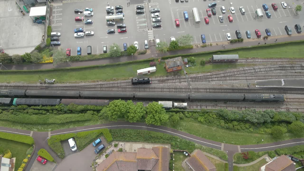 Aerial view of the Minehead steam railway station England's longest heritage line, running 20 miles between Minehead and Bishops Lydeard. Drone moving to right following one of steam train