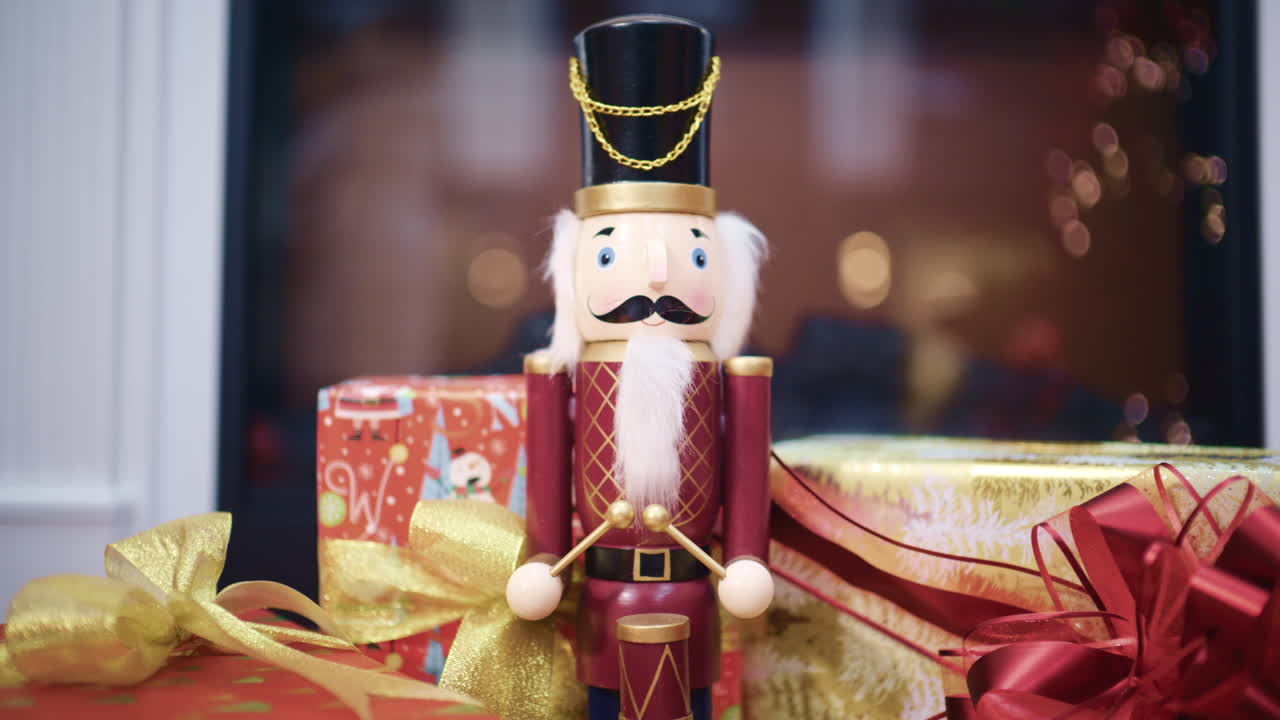 Close up of a traditional nutcracker Christmas figurine surrounded by wrapped gifts