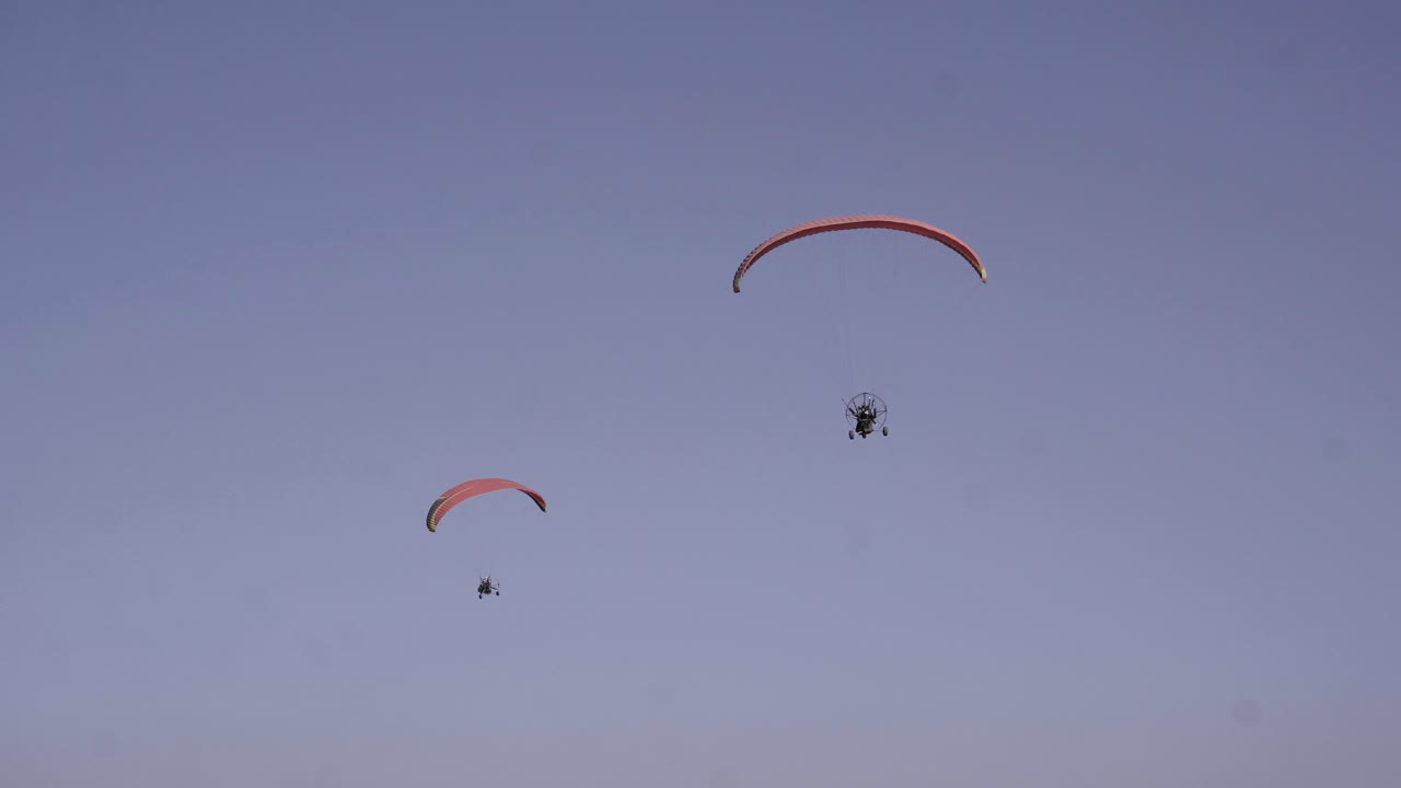 dos parapentes volando en tándem, deporte competitivo recreativo