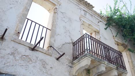 edificio abandonado con balcón y barandillas oxidadas