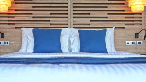 recorre una cama grande y cómoda decorada con una funda azul y cojines decorativos