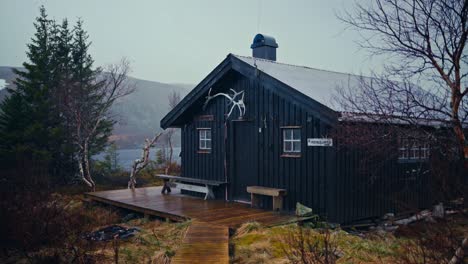 rain falls on a rustic cabin in reinsjøen, åfjord, trøndelag, norway - handheld shot