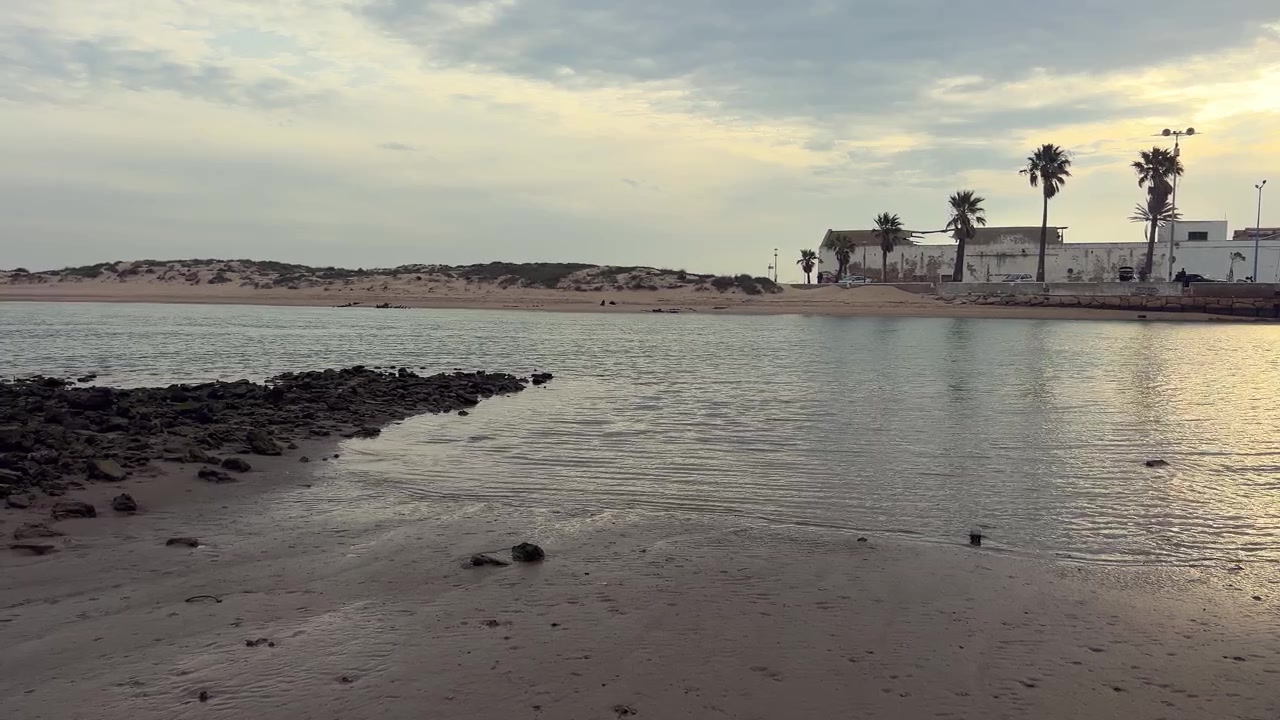 Vista estática desde la playa de un pueblo de casas blancas. Luz del día.