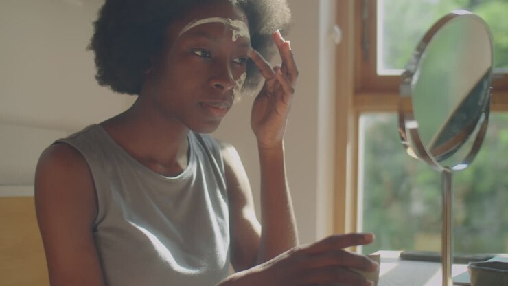 Black Woman Applying Facial Mask at Home