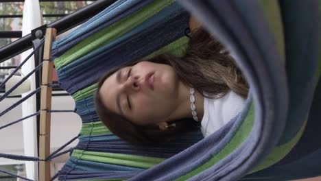 brunette teenager girl falling asleep in a hammock