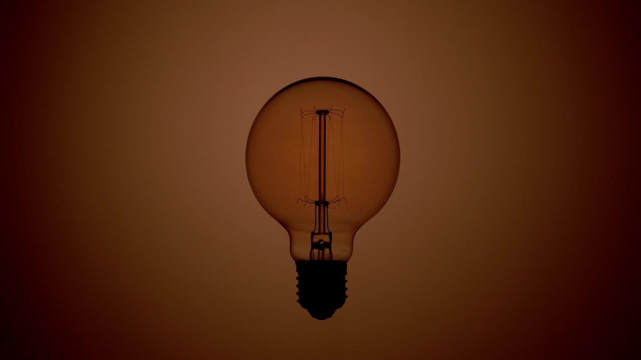 스텐 전구가 따뜻한 빛의 배경에서 박이고 있습니다.