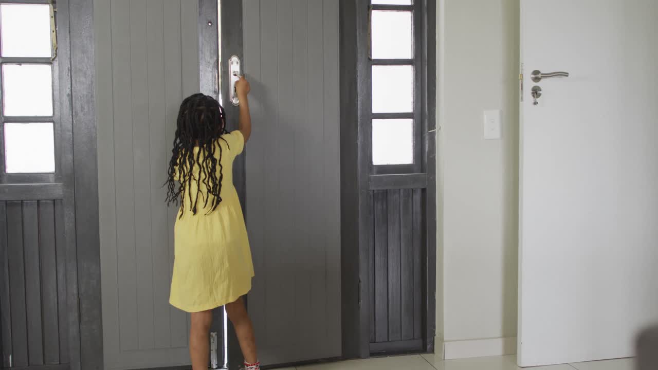 feliz hija afroamericana abriendo la puerta al padre volviendo de casa