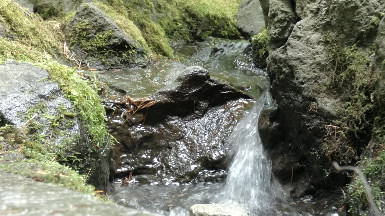 Small stream flowing around rocks eroding away the rocks