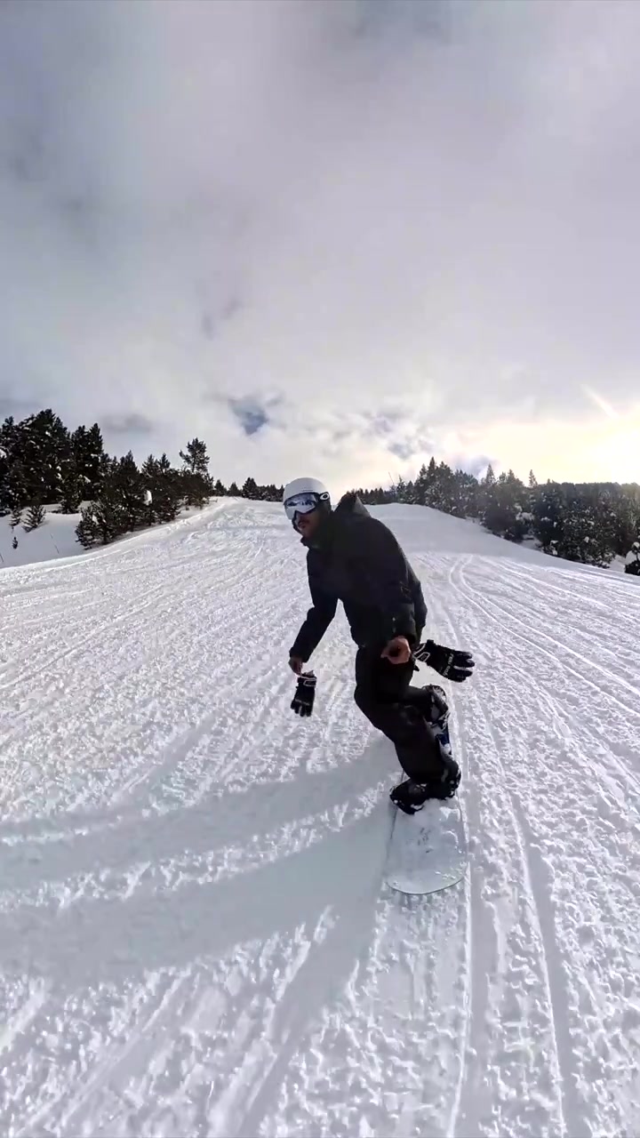 Snowboarder Riding Down a Snowy Mountain Slope