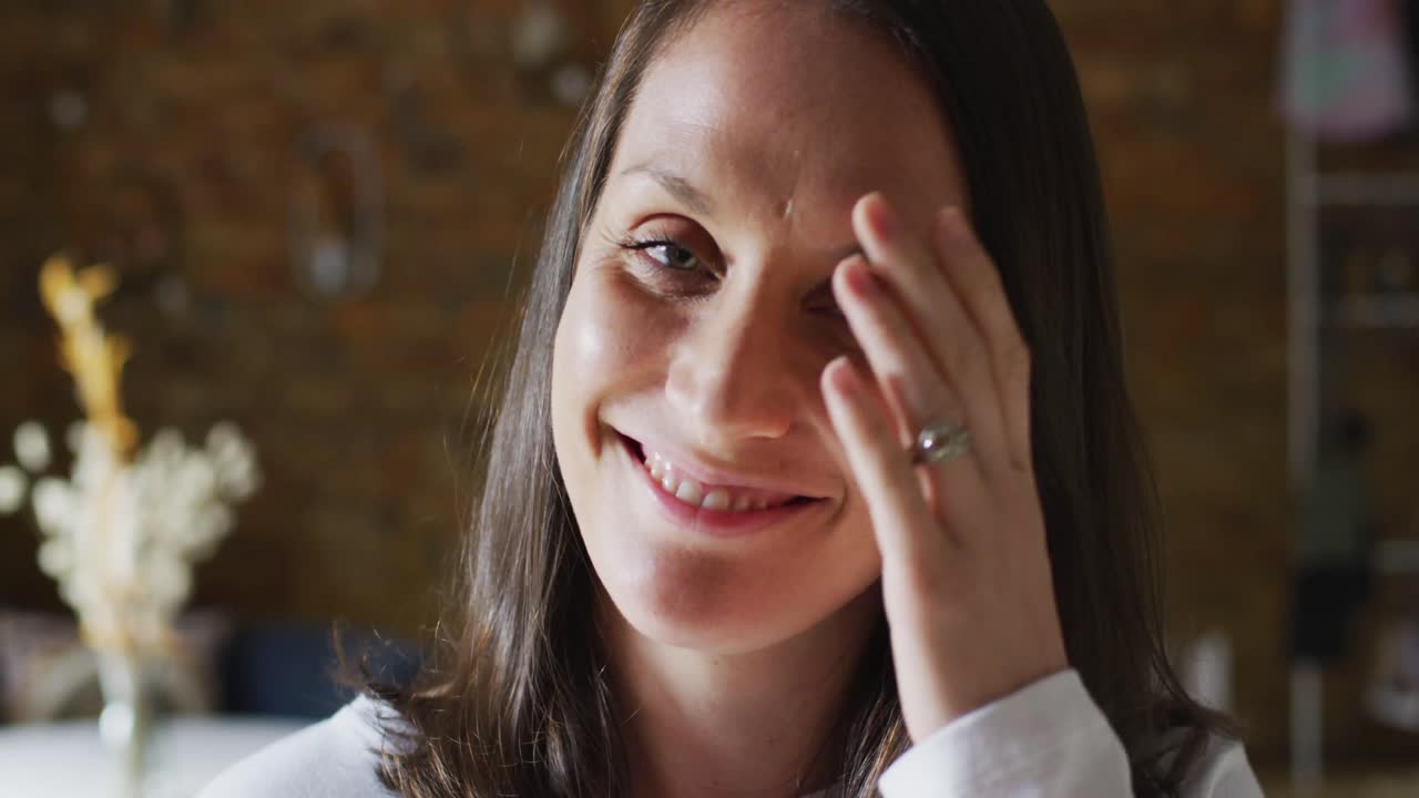 retrato de una empresaria caucásica sonriente tocando el cabello y mirando a la cámara