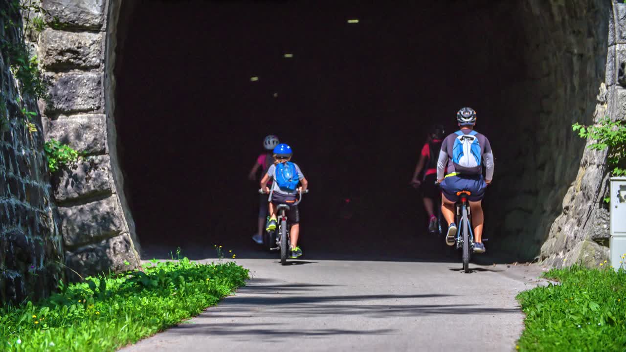 Caucasian family ride bikes through tunnel in Slovenj Gradec , Slovenia