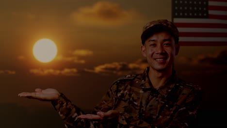 close up of asian man soldier smiling and pointing to side while standing with flag of the united states, sunset time