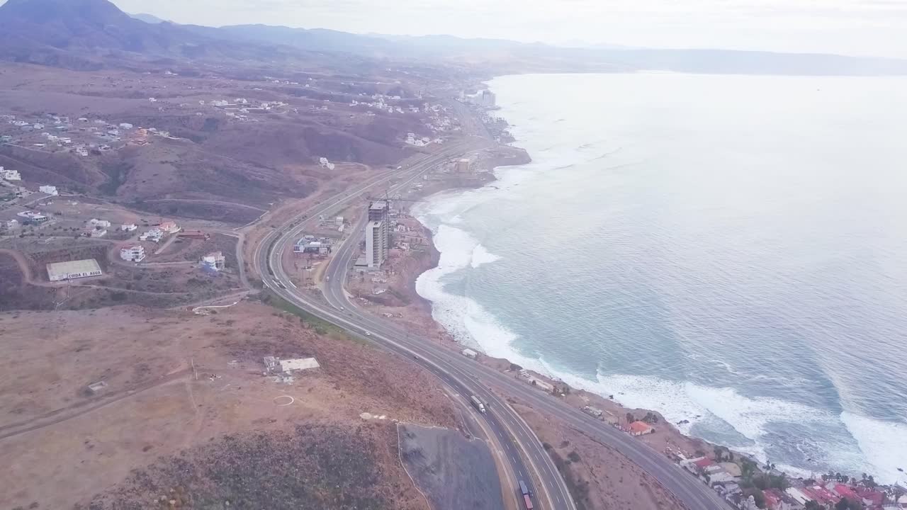 View from a drone flying over the highway, next to the beach, condominiums and hotels, in the city of Rosarito M&eacute;xico