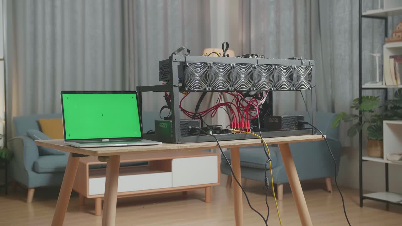 녹색 화면 노트북과 채굴 기기가 테이블 위에 cryptocurrency 채굴을 위해