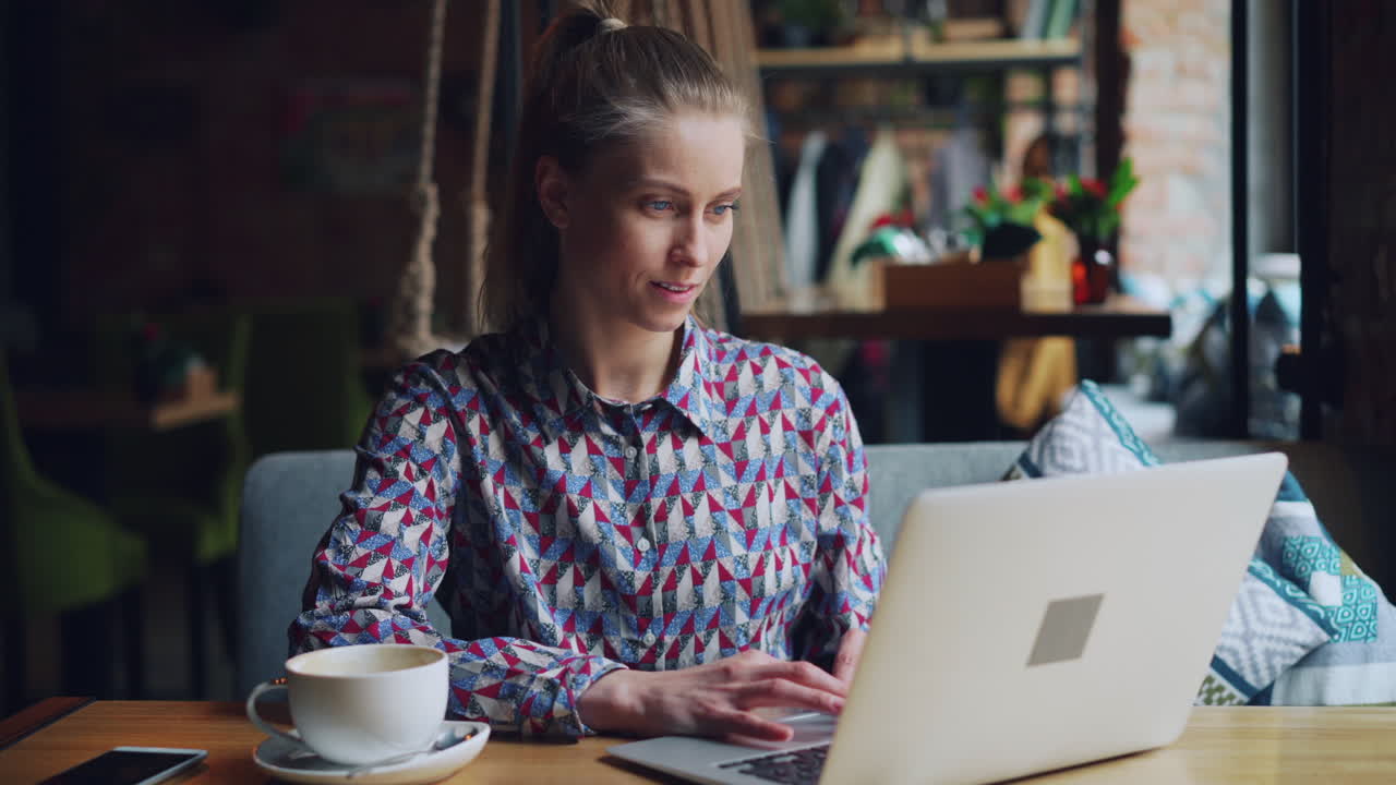 mujer trabajando en una computadora portátil en un café
