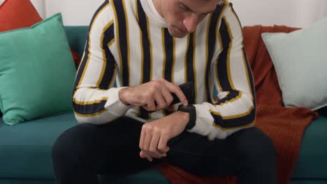 caucasian man using his phone and a smartwatch