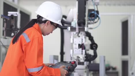el oficial profesional comprueba el robot que se mueve en la base de la pieza en la fábrica de fabricación. reparación del brazo robótico en el laboratorio de investigación, uso de gafas de protección, uso de computadora compruebe el bucle del programa.
