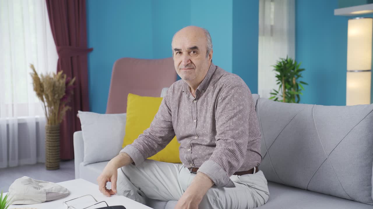Anziano che fa un gesto negativo alla telecamera.