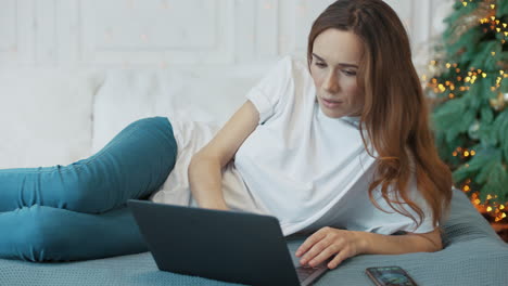 Serious-business-woman-looking-computer-screen-in-luxury-bedroom