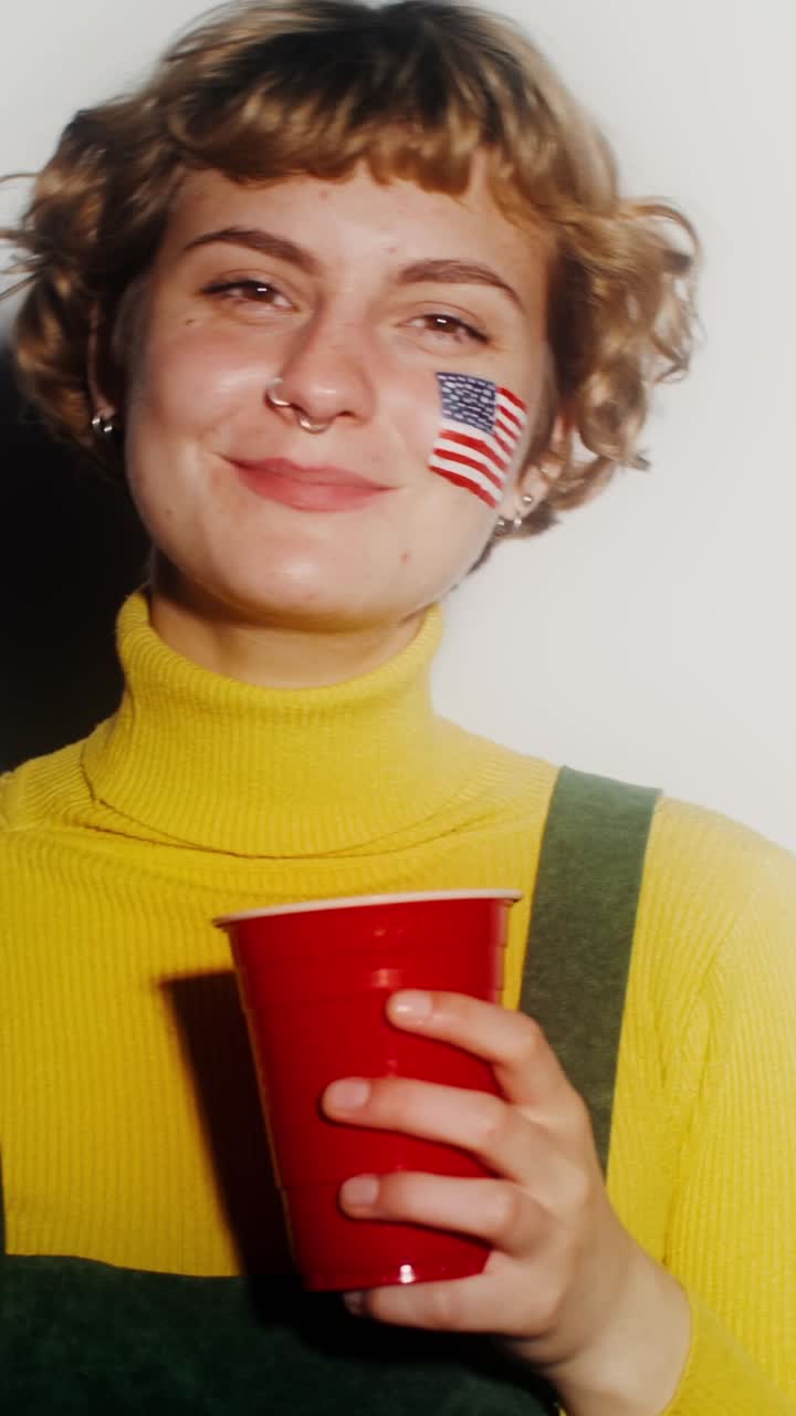 donna con la faccia dipinta con la bandiera americana e accessori per il giorno delle elezioni