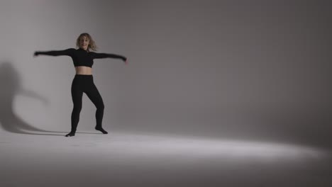 Full-Length-Studio-Shot-Of-Young-Woman-Doing-Dance-Practise-Against-Grey-Background-3