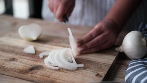 chef cutting an onion with a knife.