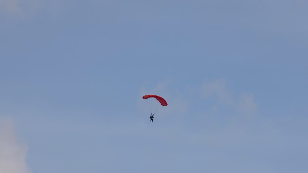 은 날 에 낙하산 을 타고 내려가는 사람